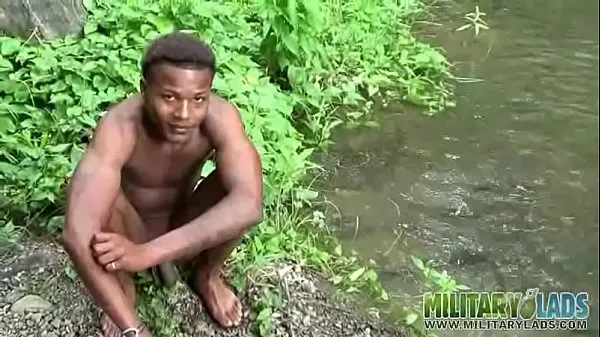 Brown soldier strips naked by the stream أنبوب دافئ كبير