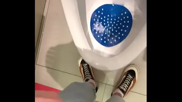 Big peeing in a urinal in a public toilet warm Tube